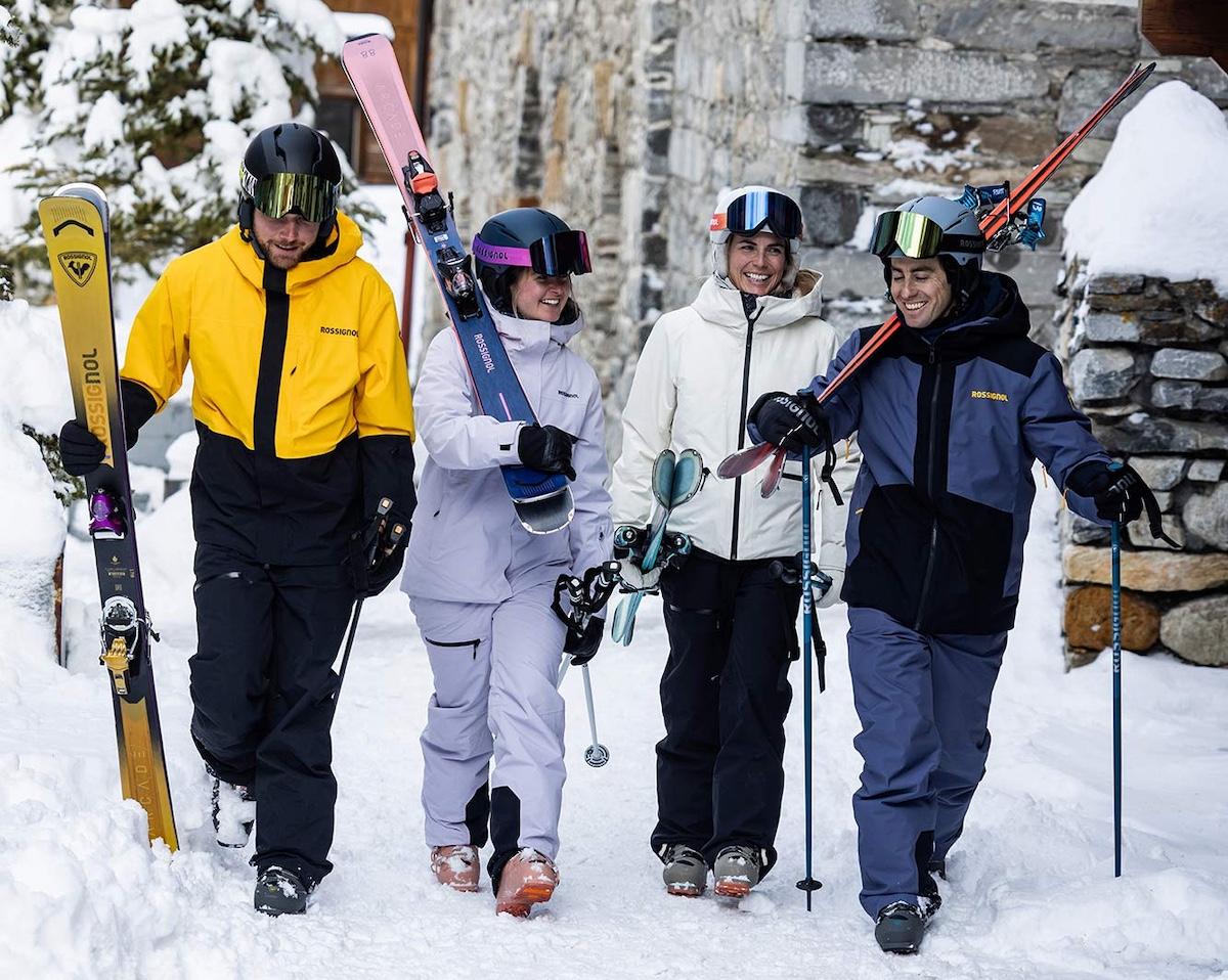 Vier Skifahrer gehen durch das Skigebiet
