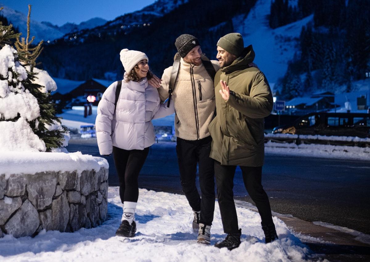 Skifahrer spazieren nach einem Skitag durch das Dorf